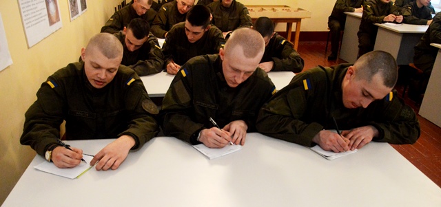 Бійці Національної гвардії зосередженно працюють над диктантом.